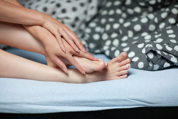 Frau Die Auf Dem Bett Sitzt Und Ihre Füße Hält — Stockfoto
