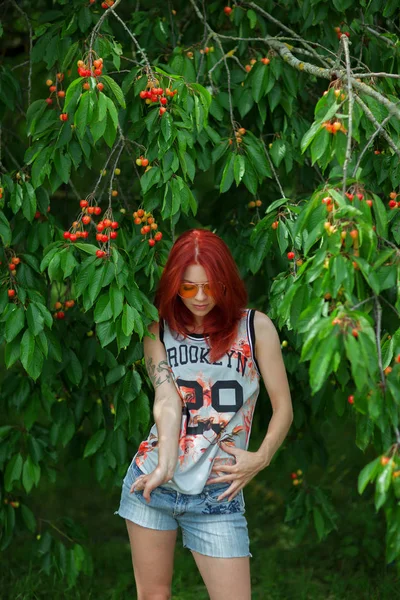 Schöne Frau Mit Roten Haaren Vor Einem Kirschbaum Mit Reifen — Stockfoto