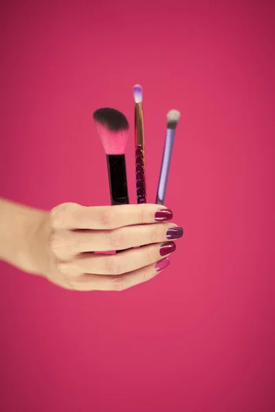 Womans Hand Perfect Pink Nail Polish Holding Cosmetic Brushes Front — Stock Photo, Image