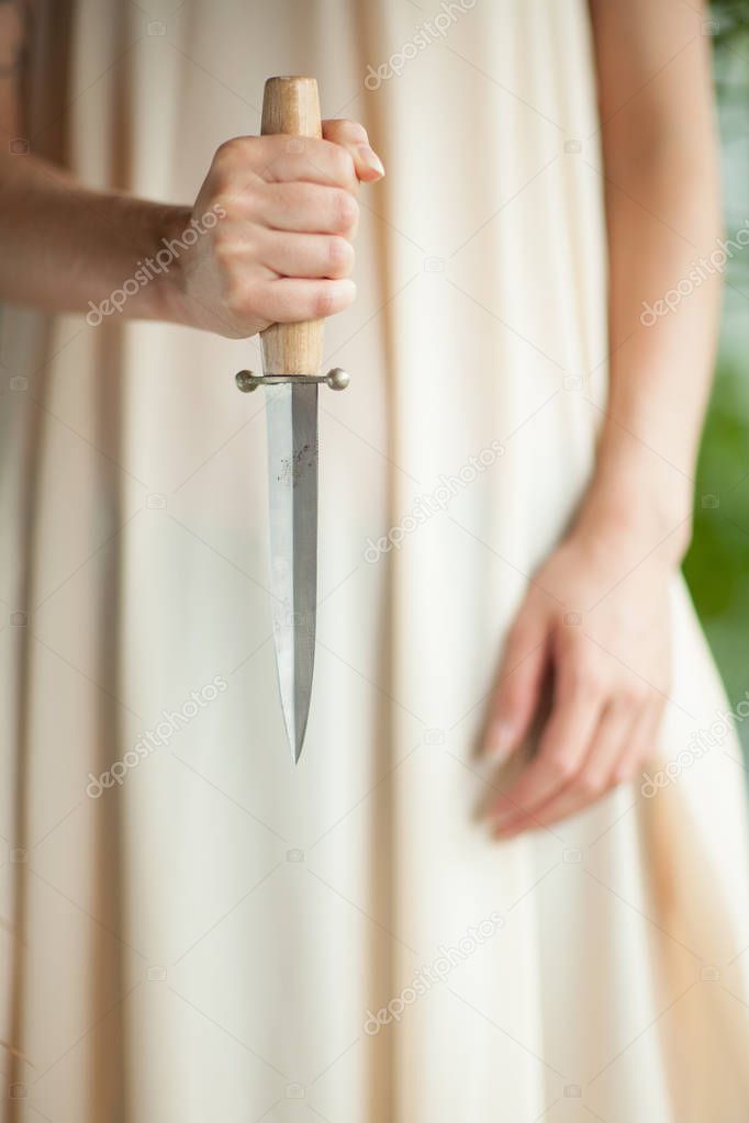 woman's hands holding a sharp knife, close up concept, can be used as background