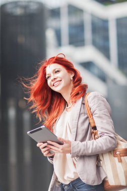 Şehir merkezinde, açık havada çalışan tablet, tutan genç güzel iş kadın