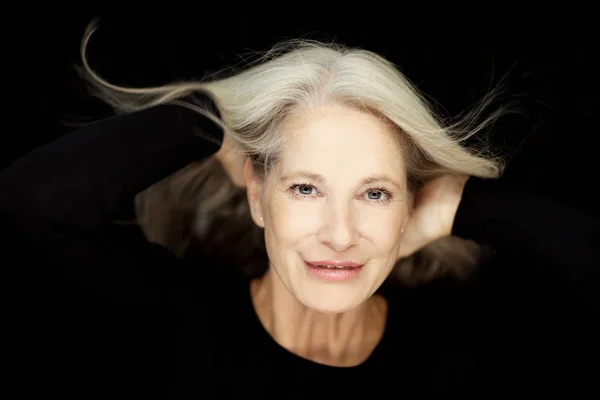 令人惊叹的美丽和自信的最佳老年妇女与灰色的头发微笑成相机 肖像与黑色背景 — 图库照片