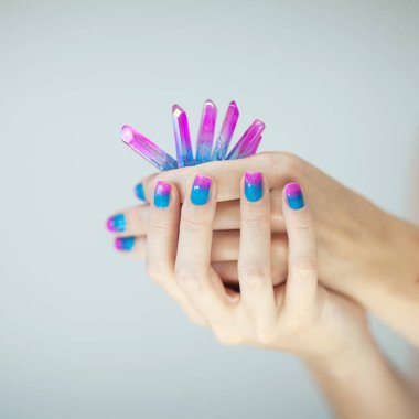 Güzel kadın eller mükemmel mor pembe ve turkuaz küçük renk eşleştirme kuvars kristalleri, holding oje ile arka plan olarak kullanılabilir 