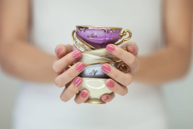 Güzel kadın elinde tutan küçük vintage çay bardak, romantik shabby chic ruh hali, mükemmel pembe tırnak cilası ile arka plan olarak kullanılabilir