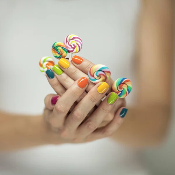 Beautiful Woman Hands Rainbow Nail Polish Holding Colorful Swirl Lollypops — Stock Photo, Image