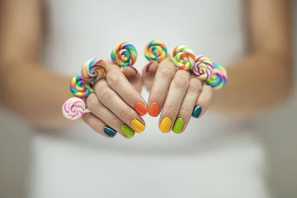 Piękna Kobieta Ręce Rainbow Paznokci Polski Holding Kolorowe Wirowa Lizaki — Zdjęcie stockowe