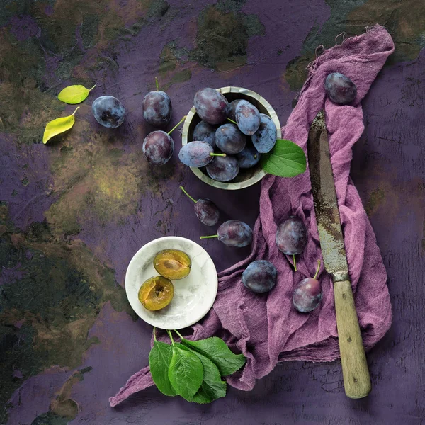 葉とナイフ 素朴な料理写真とバイオレットの紫色の背景に装飾された庭から支店に新鮮でおいしい梅 — ストック写真