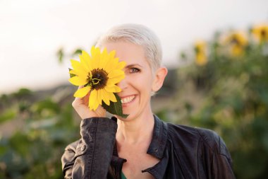 Güneş ışığı, kapışma, zevk ayçiçeği Sonbahar ruh açık havada duran bir kırsal alan sahne güzel orta yaş kadında