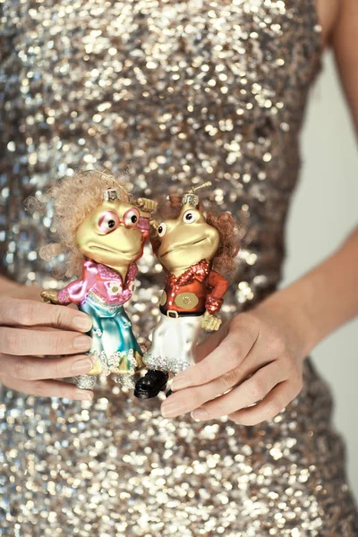 Руки Женщины Закрываются Держа Рождественские Игрушки Маленькие Танцующие Лягушки Сверкающие — стоковое фото