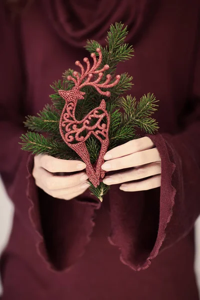 美丽的女子手关闭举行圣诞装饰 闪光的驯鹿在红色 完美的法国指甲 可作为背景 — 图库照片