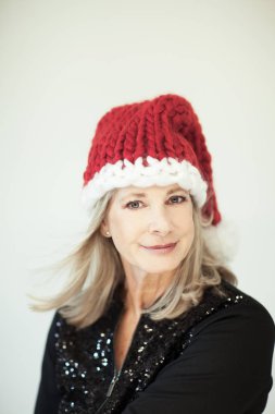Noel babalar küçük yardımcısı. Mükemmel bir Noel Baba şapkası ile güzel mutlu üst düzey kadın makyaj, arka plan olarak kullanılabilir 