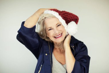 Noel babalar küçük yardımcısı. Bir santa claus şapka ve kış ceket, mükemmel güzel mutlu üst düzey Bayan makyaj, arka plan olarak kullanılabilir 