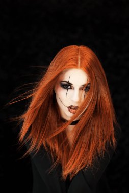 Güzel, Genç ve kadın ile halloween makyaj siyah arka plan önünde Kızıl saçlı pozlar