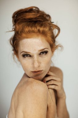 Mükemmel uzun kırmızı kıvırcık saçlı ve çilli olan güzel bir kadın portresi, makyaj