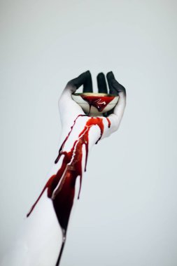 Ürpertici Halloween kadın canavar eli kanlı ve beyaz ile kol ve siyah yapmak vintage Kupası kan beyaz arka plan önünde gidiyor