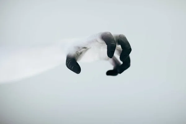 Creepy Halloween monster hand with white and black make up in front of white background