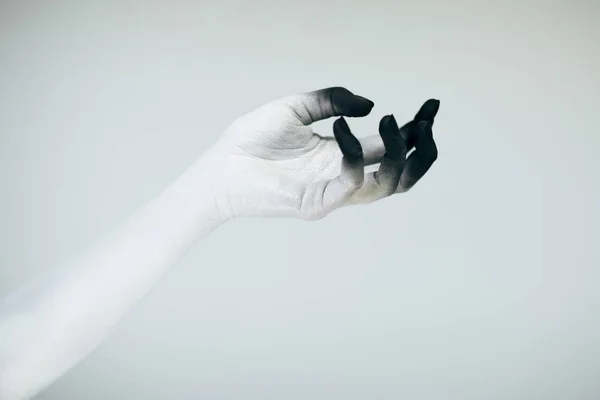 Creepy Halloween monster hand with white and black make up in front of white background