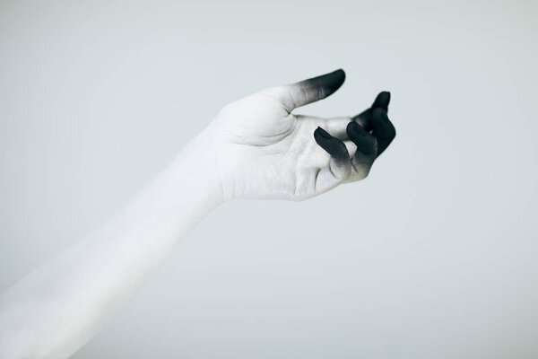 Creepy Halloween monster hand with white and black make up in front of white background