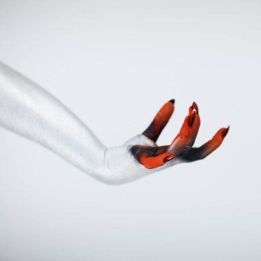 Korkunç Halloween canavar cadı el Beyaz, kırmızı ve siyah makyaj ve beyaz arka plan önünde uzun tüyler ürpertici tırnakları ile 