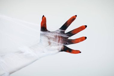 Korkunç Halloween canavar cadı el ile beyaz, kırmızı ve siyah makyaj ve uzun tüyler ürpertici tırnakları ve beyaz arka plan önünde spiderweb