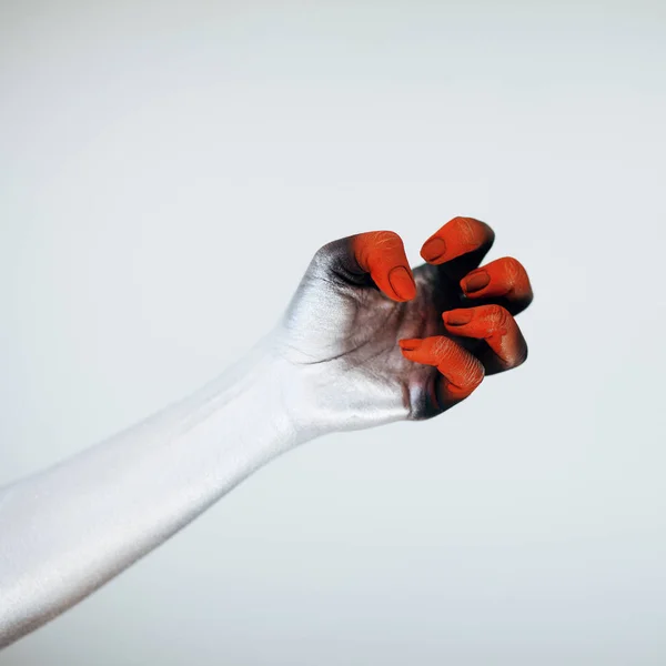 Creepy Halloween monster hand with white, red and black make up in front of white background