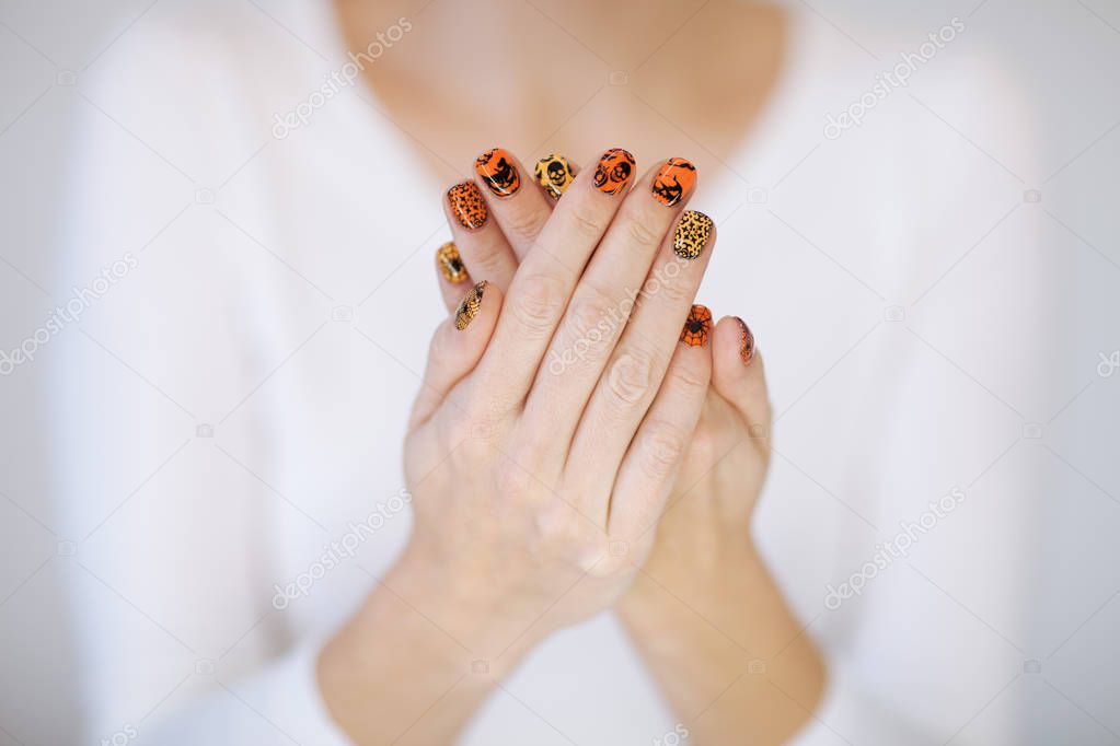 Beautiful woman hands with cute halloween nail polish can be used as background