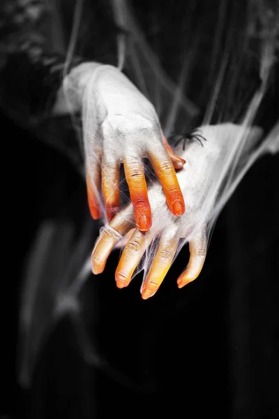 Creepy halloween hand in green and white with spider web, zombie hand on black background