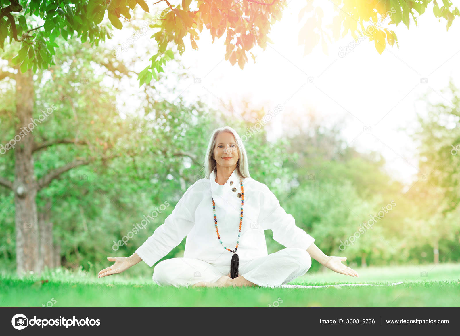 Senior woman with gray hair exercising yoga at home on a mat in front of a  white wall asana pigeon intro Stock Photo  Alamy
