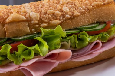 Baget ekmekli doğal sandviç. Peynir, jambon, marul, domates ve salatalık..