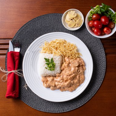 Pirinç, salata ve patates pipetli tavuk stroganoff..