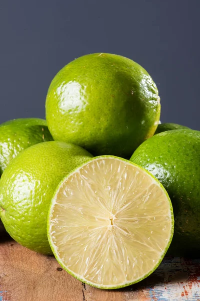 Lemon cut in half with some lemons in the background on wooden table. Lime.