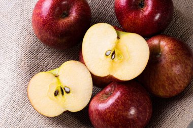 Elma, arka planda bir sepette elmalarla ikiye bölünmüş. Ahşap arkaplan.