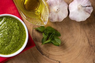 Fonda malzemeler olan bir kasede pesto sosu. Zeytinyağı, sarımsak ve fesleğen. Boşluğu kopyala