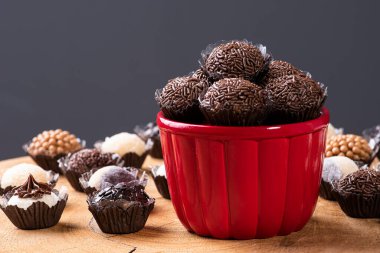 Brigadeiro. Typical Brazilian sweet. Several brigadiers in a bowl. Surrounded by various types of brigadiers. Selective focus clipart