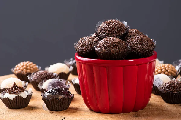 Brigadeiro. Tipik Brezilya tatlısı. Bir kasede birkaç tugay. Etrafı çeşitli tugaylarla çevrili. Seçici odak