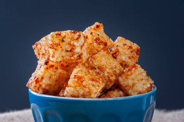 Biber jölesiyle servis edilen muhallebi ve peynir kareleri. Tahta masa..