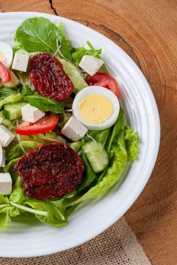 Marullu yeşil salata, roka, salatalık, peynir, kurutulmuş domates ve haşlanmış yumurta..