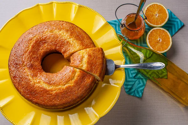 Homemade orange cake in a beautiful yellow cake holder. Top view