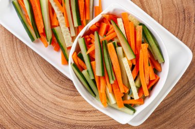 Sebzeler kürdan, havuç ve salatalık şeklinde kesilmiş. Çiğ sebze salatası. Spor yemeği. Üst görünüm.