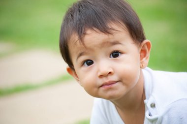 Bahçede tek başına oynayan Asyalı bir kızın portresi. Açık hava sahnesi. Seçici odaklanma. Boşluğu kopyala.