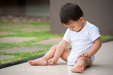 Bahçede tek başına oynayan Asyalı bir kızın portresi. Açık hava sahnesi. Boşluğu kopyala