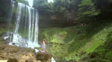 Rüzgar Bayan uzun saç ayakta kayada sallıyor.