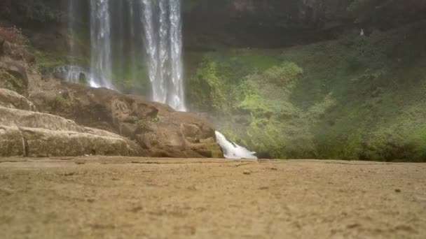 Enormes rocas marrones contra una poderosa cascada — Vídeo de stock