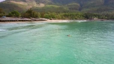 dalgalara karşı yeşil hill tarafından Kum Plajı üzerinde sörf harika üst resim kadın sörfçü acemi oturur