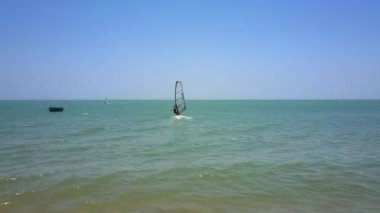 mavi gökyüzünün altında masmavi okyanus plaj hareketli adet rüzgar sörfü acemi şeffaf yelken ile başlar