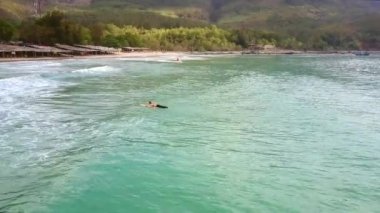 gemide üst panorama kız sörfçü acemi yüzüyor ve izlemek yapım yüksek hızda su-scooter geçer
