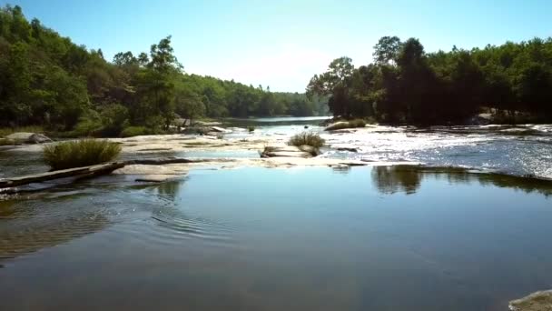 Τρέχει rapids ποταμού στο βουνό ανάμεσα σε βράχια, κάτω από το φως του ήλιου — Αρχείο Βίντεο