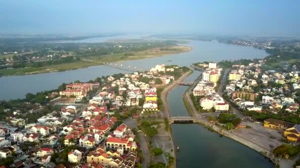 Kanaal bruggen verbinden Hoian districten tegen rivierlandschap — Stockvideo
