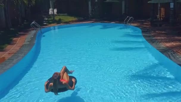 Mujer pasa tiempo libre tomando el sol en la boya de la vida en la piscina — Vídeos de Stock