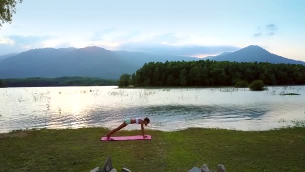 女孩图改变瑜伽对尼斯湖的姿势 — 图库视频影像